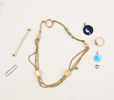 a close up of a gold chain bracelet with a blue glass pendant