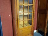 un meuble en bois avec une porte en verre dans une pièce