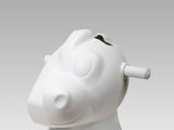 a white pig shaped vase with a toothbrush in it