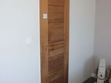 un lit blanc dans une chambre, à côté d'une porte en bois