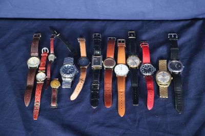 Plusieurs modèles de montres sont alignés sur un tissu bleu