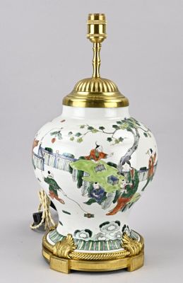 une image représentant un vase blanc avec un socle doré et une lampe posée dessus