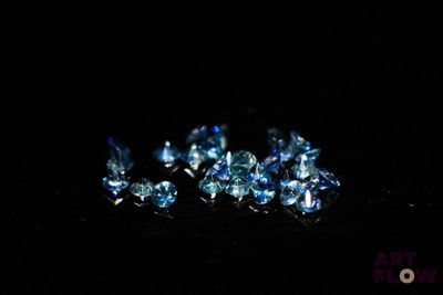 some very pretty blue diamonds sitting on top of a black surface