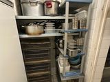 many pots and pans on the shelves in the kitchen