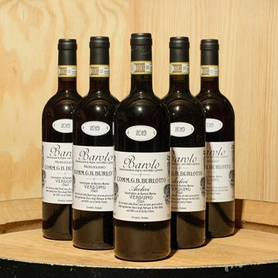 six bottles of wine sitting on top of a wooden barrel