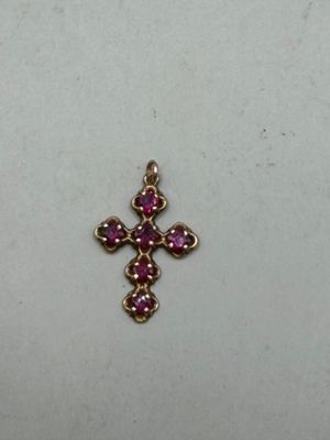 a close up of a small cross on a white surface