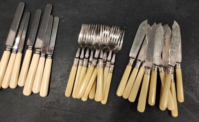 several forks and knives are lined up on a table