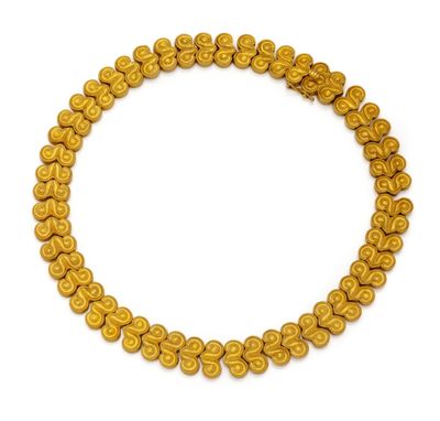 un gros plan d'un collier de perles dorées sur fond blanc