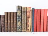several old books are lined up in a row on a white surface