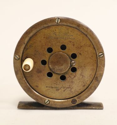 a close up of a small fishing reel on a stand