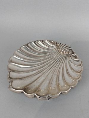 petit plat en forme de coquillage plaqué argent sur un fond blanc