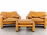 two brown leather chairs and a ottoman in a white room