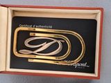 a silver and gold brooch in a red box