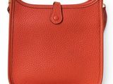 a red leather purse with a gold clasp on the front