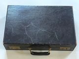 une valise noire posée sur une surface blanche