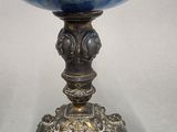an antique silver and blue glass goblet with a woman in the center