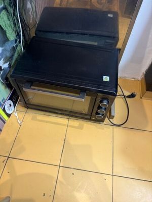 a toaster oven sitting on a tiled floor in a kitchen