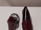 two pairs of red shoes sitting on top of a white table