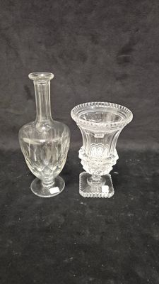 two glass vases sitting next to each other on a black surface