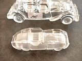 deux petites voitures en plastique transparent posées sur une table