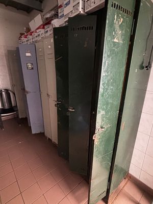 une rangée de cabines vertes et blanches dans des toilettes publiques
