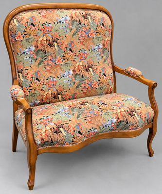 une chaise avec un dossier et des accoudoirs tapissés de fleurs