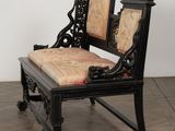 a black chair with a cushion on it on a wooden floor