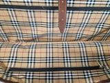 a close up of a brown and black plaid backpack with a brown handle
