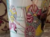 a vase with a painting on it sitting on a table