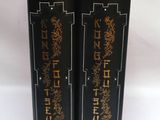 deux boîtes noires ornées d'inscriptions dorées, posées sur une surface blanche