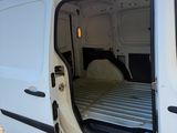 une camionnette blanche dont les portes sont ouvertes et qui comporte un lit à l'arrière