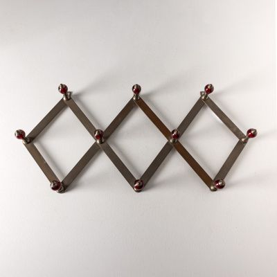 un gros plan sur une étagère métallique fixée au mur, ornée de perles rouges