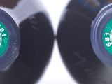 two bottles of wine sitting next to each other on a table