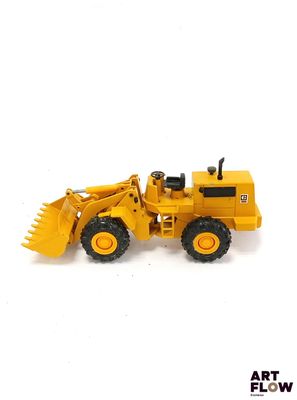 un bulldozer jouet jaune sur fond blanc