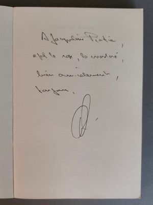un livre ouvert, sur lequel est posée une note manuscrite, posé sur une table