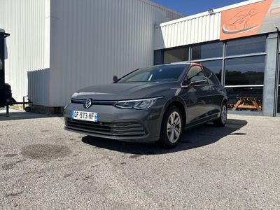 une Volkswagen e-Golf grise garée devant un immeuble