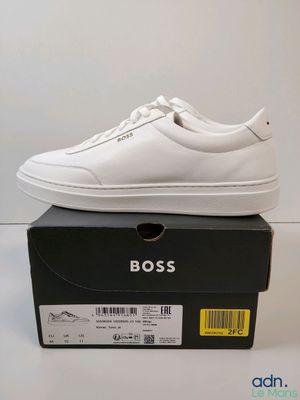 une paire de chaussures blanches posée sur une boîte