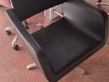 a black chair sitting in front of a pink desk
