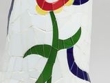 a white vase with a red flower on it