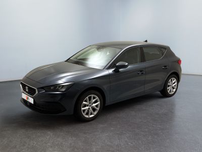 Une voiture grise est garée dans une pièce au sol noir.