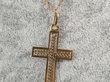 a gold cross pendant on a gold chain