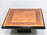 a close up of a square table with a wooden top