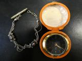 une montre de poche attachée à une chaîne, posée sur une table