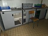 a small kitchen with a refrigerator and a chair in it