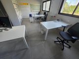 a room with a desk, chair, and computer monitor in it