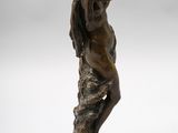 a bronze statue of a woman holding a bird in her hand