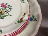 three plates with flowers on them sitting on a table