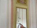 a mirror hanging on the wall above a bed