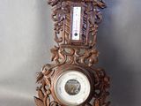 une horloge posée sur une table sur laquelle se trouve un baromètre