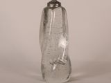 une bouteille en verre transparent avec un bouchon argenté, posée sur une surface blanche